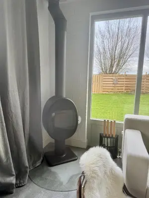 a white dog sitting in a living room with a tv at Bungalowpark de Horn - 128 in Dirkshorn