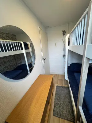 a room with two bunk beds and a mirror at Bungalowpark de Horn - 128 in Dirkshorn