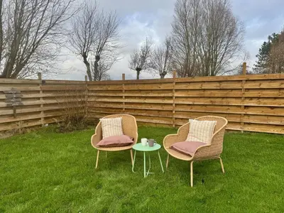 two chairs and a table in the grass at Bungalowpark de Horn - 128 in Dirkshorn