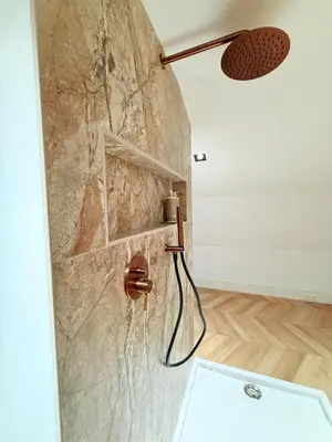 a shower in a bathroom with a stone wall at Luxury Apartment near Amsterdam in Purmerland