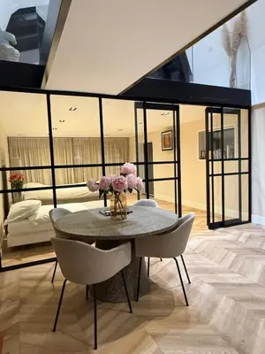 a dining room with a table with pink flowers on it at Luxury Apartment near Amsterdam in Purmerland