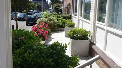 a balcony with flowers on the side of a building at Hotel Golfzicht in Noordwijk aan Zee