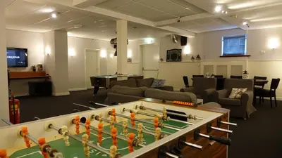 a living room with a pool table and a room with at Hotel Golfzicht in Noordwijk aan Zee