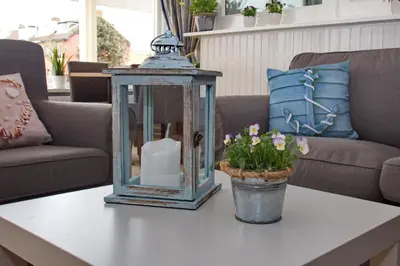 a table with a lantern and flowers on it at Hotel Golfzicht in Noordwijk aan Zee
