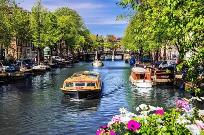 two boats are docked on a canal in a city at Spacious and Cozy House with Affordable Parking in Amsterdam