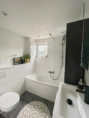 a bathroom with a tub and a toilet and a sink at Spacious and Cozy House with Affordable Parking in Amsterdam