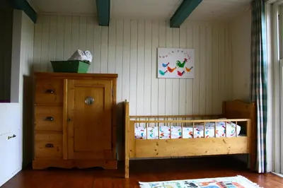 a bedroom with a wooden bed and a wooden dresser at Droomgaerd in Vlist