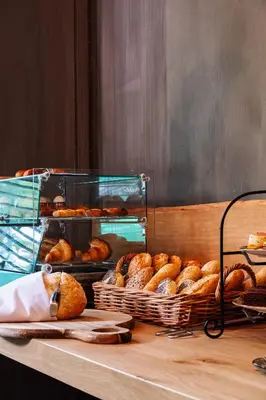 a table with baskets of bread and pastries on it at City Center Lodge Utrecht in Utrecht