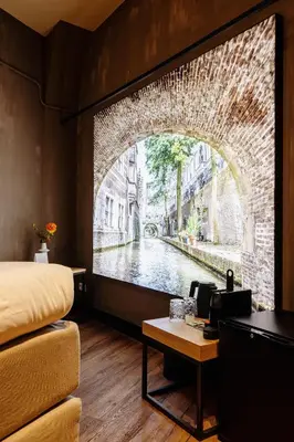 a room with a bed and a view of a canal at City Center Lodge Utrecht in Utrecht