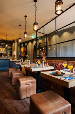 a restaurant with tables and chairs and a bar at City Center Lodge Utrecht in Utrecht