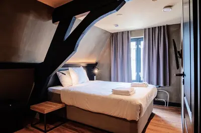 a bedroom with a bed with a black and white ceiling at City Center Lodge Utrecht in Utrecht
