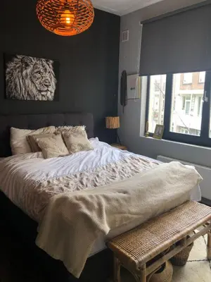 a bedroom with a large bed and a window at Cozy apartment with large roof terrace in Amsterdam
