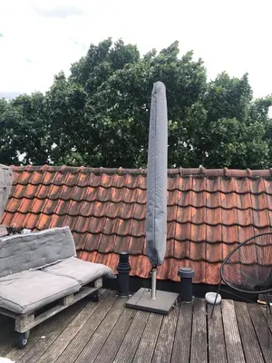 an umbrella and a bench on a wooden deck at Cozy apartment with large roof terrace in Amsterdam