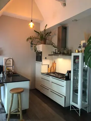 a kitchen with a stove top oven next to a counter at Cozy apartment with large roof terrace in Amsterdam
