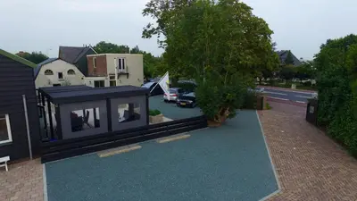 a small black house on the side of a street at Guest House Aan de Hollandse IJssel in Montfoort