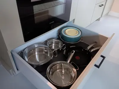 a kitchen stove with pots and pans in a drawer at Guesthouse Voorhout in Voorhout