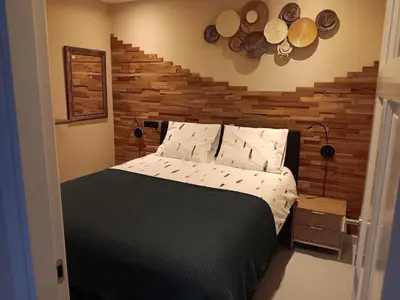 a bedroom with a bed with a wooden wall at Guesthouse Voorhout in Voorhout
