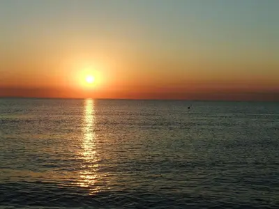 a sunset over the ocean with the sun setting at Guesthouse Voorhout in Voorhout