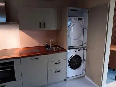 a kitchen with a washing machine and a washer at Guesthouse Voorhout in Voorhout