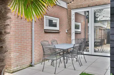 a table and chairs sitting on a patio at Pats garden room with mini cinema, projector in Alkmaar