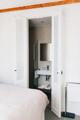 a bedroom with a white bed and a sink at Boutique B&B Bovien in Amsterdam