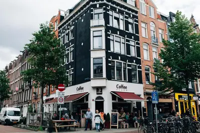 a tall black and white building on a city street at Boutique B&B Bovien in Amsterdam