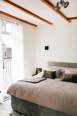 a bedroom with a large bed and a window at Boutique B&B Bovien in Amsterdam