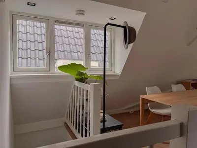 a room with a staircase and a window with a plant at New V Luxury Apartment in Amsterdam