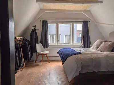 a bedroom with a bed and a window and a chair at New V Luxury Apartment in Amsterdam