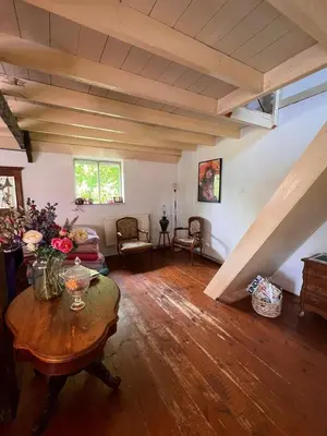 a living room with a table and an attic at Privé huisje op unieke groene plek in Den Dolder