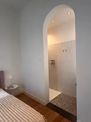 a bedroom with a shower with a bed and a mirror at In de Pastorie Utrecht - Old rectory, just steps away from the city center in Utrecht