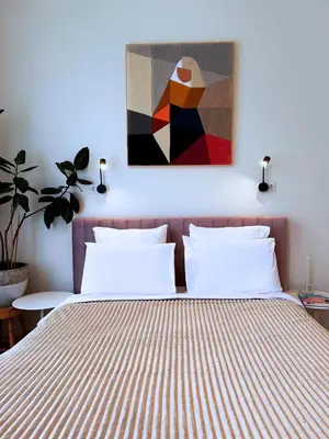 a bedroom with a bed with a painting above it at In de Pastorie Utrecht - Old rectory, just steps away from the city center in Utrecht