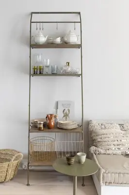 a metal shelf with dishes on it next to a table at Palm Tree in Bergen