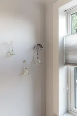 three vases with flowers on a wall next to a window at Palm Tree in Bergen