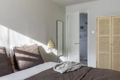 a bedroom with a bed with a mirror on the wall at Palm Tree in Bergen