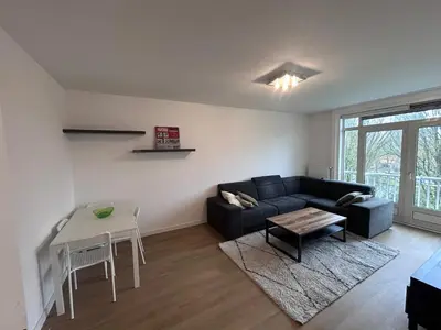 a living room with a couch and a table at Gezellig Appartement in Amsterdam-Noord in Amsterdam