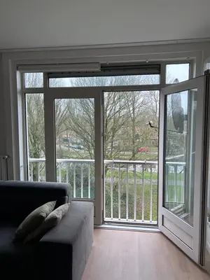 a living room with a large sliding glass door at Gezellig Appartement in Amsterdam-Noord in Amsterdam