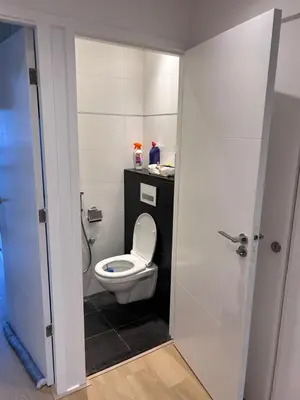 a bathroom with a white toilet and a shower at Gezellig Appartement in Amsterdam-Noord in Amsterdam