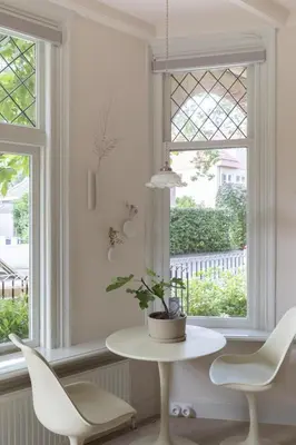 a white table and chairs in front of a window at Magnolia Tree in Bergen