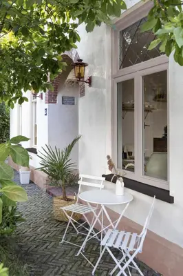 a white table and chairs on a patio at Magnolia Tree in Bergen