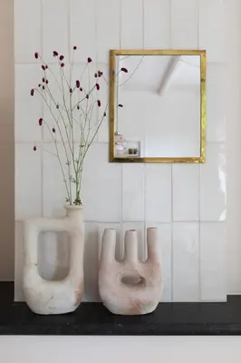 two white vases sitting on a counter with a mirror at Magnolia Tree in Bergen