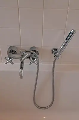 a shower head with a hose in a bathroom at Villa de Horizon in Bergen aan Zee