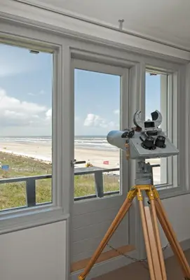 a camera on a tripod in front of a window at Villa de Horizon in Bergen aan Zee
