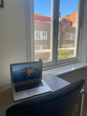 a laptop computer sitting on a desk next to a window at Beautiful quiet Apt in the center of Amsterdam in Amsterdam