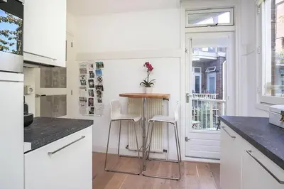 a kitchen with a small table and two stools at Beautiful quiet Apt in the center of Amsterdam in Amsterdam