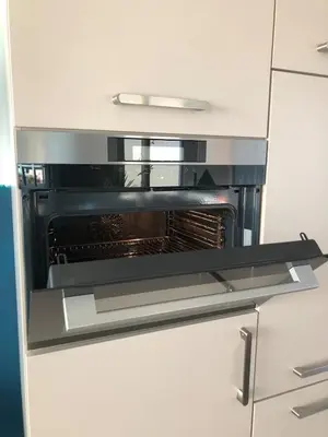 an oven in a kitchen with white cabinets at Family beach house in Egmond aan Zee
