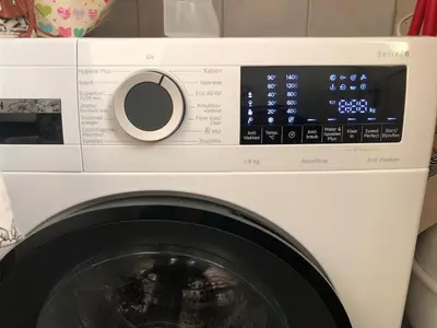 a white washing machine with a digital clock on it at Family beach house in Egmond aan Zee