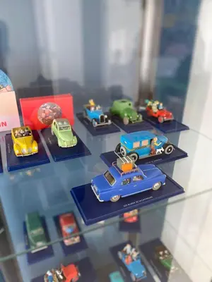 a group of toy cars on display in a glass case at Kuifje aan Zee in Egmond aan Zee