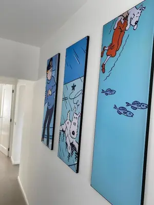 a row of four pictures on a wall at Kuifje aan Zee in Egmond aan Zee