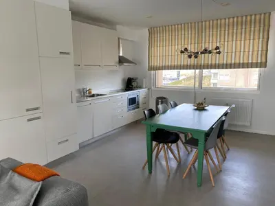 a kitchen with a table and chairs in a room at Kuifje aan Zee in Egmond aan Zee